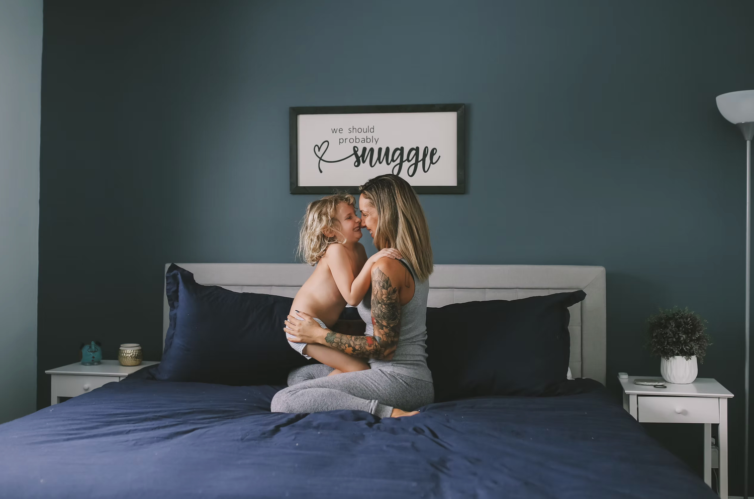 Cozy indoor photography session with moody lighting and teal colored walls.