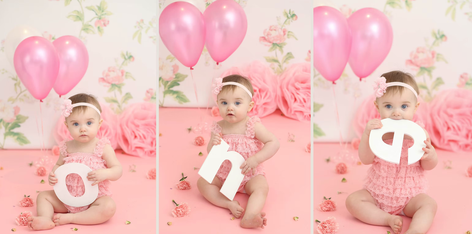 Pink themed first birthday setup with balloons and floral decorations.