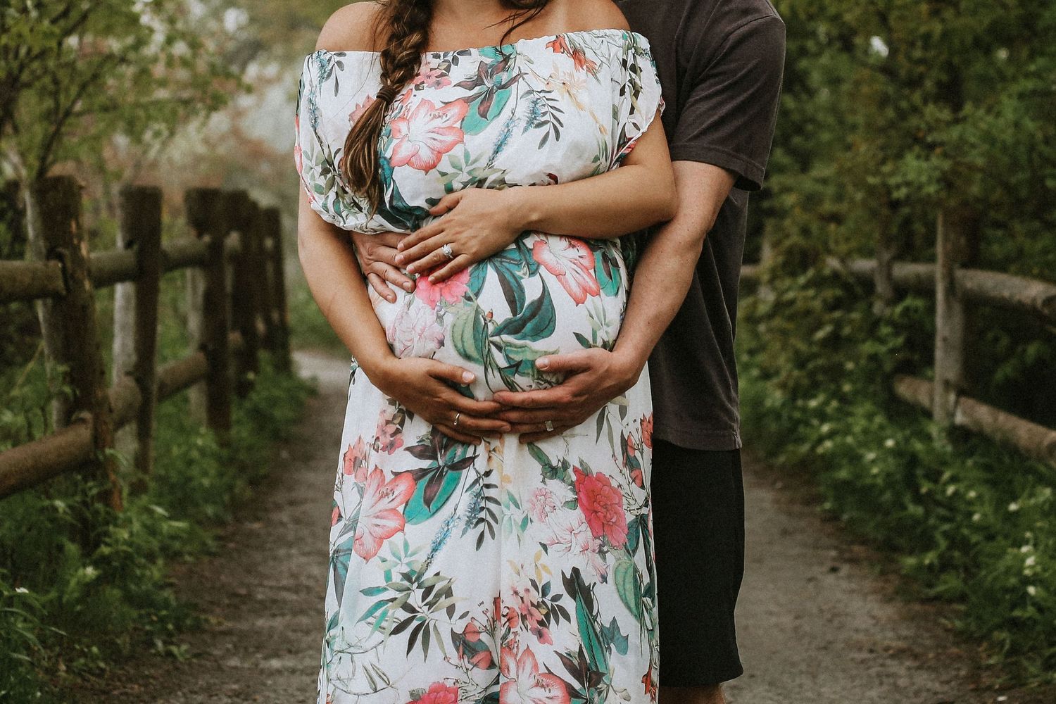 Intimate maternity photos on a tree-lined path with natural lighting.