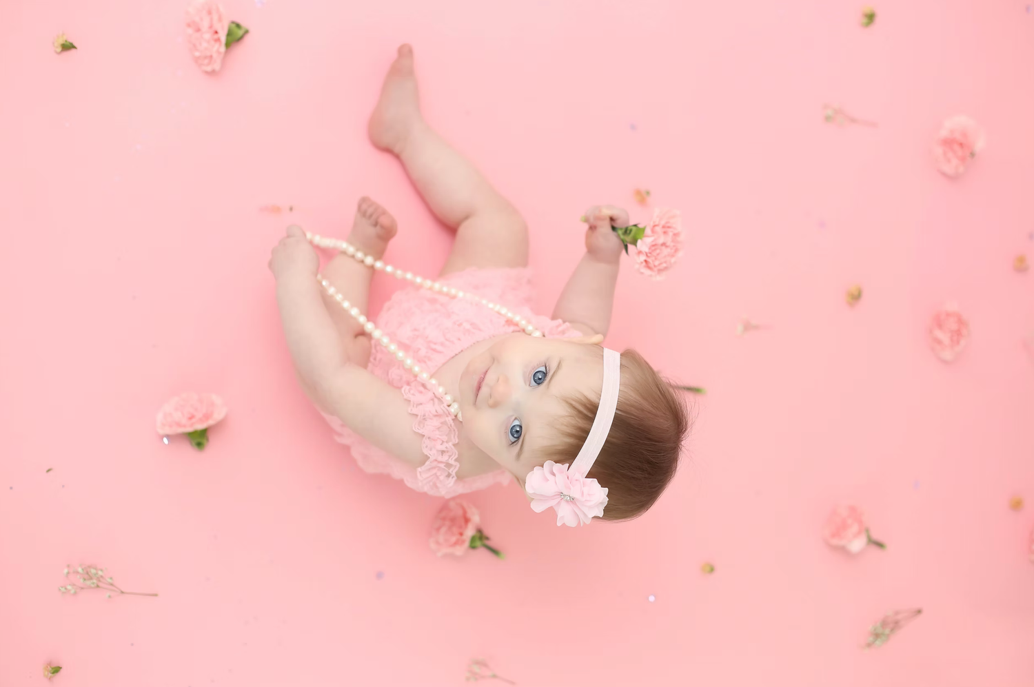 Delicate pink and gold party decorations with scattered metallic confetti and balloons.