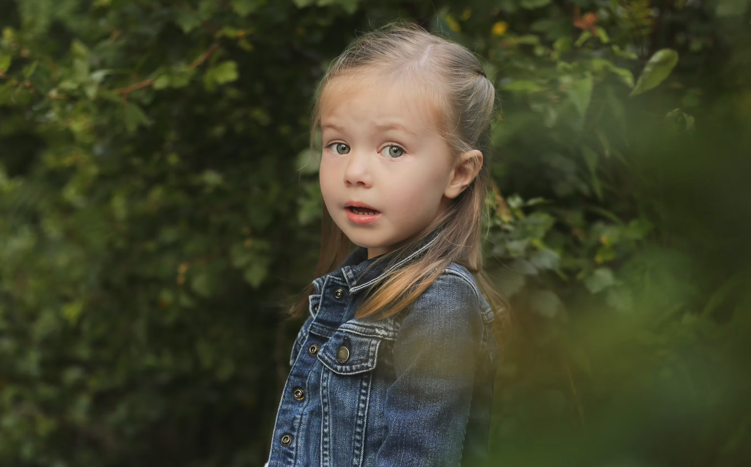 Natural outdoor portrait session among green foliage.