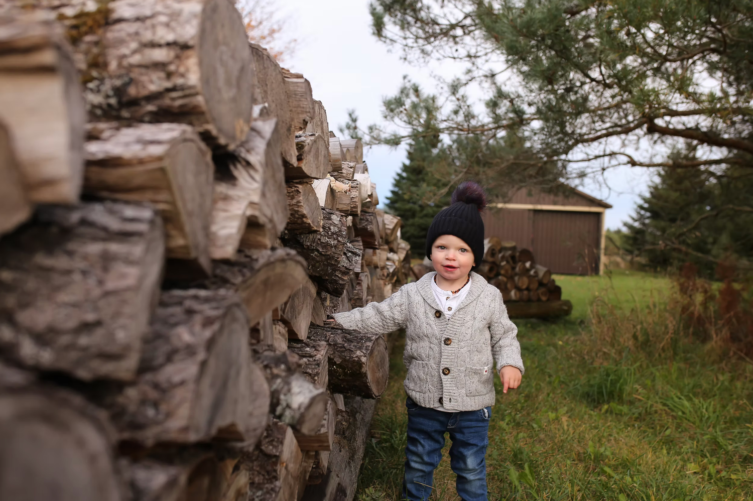 Family enjoying a relaxed moment together outdoors near rustic wooden structures.