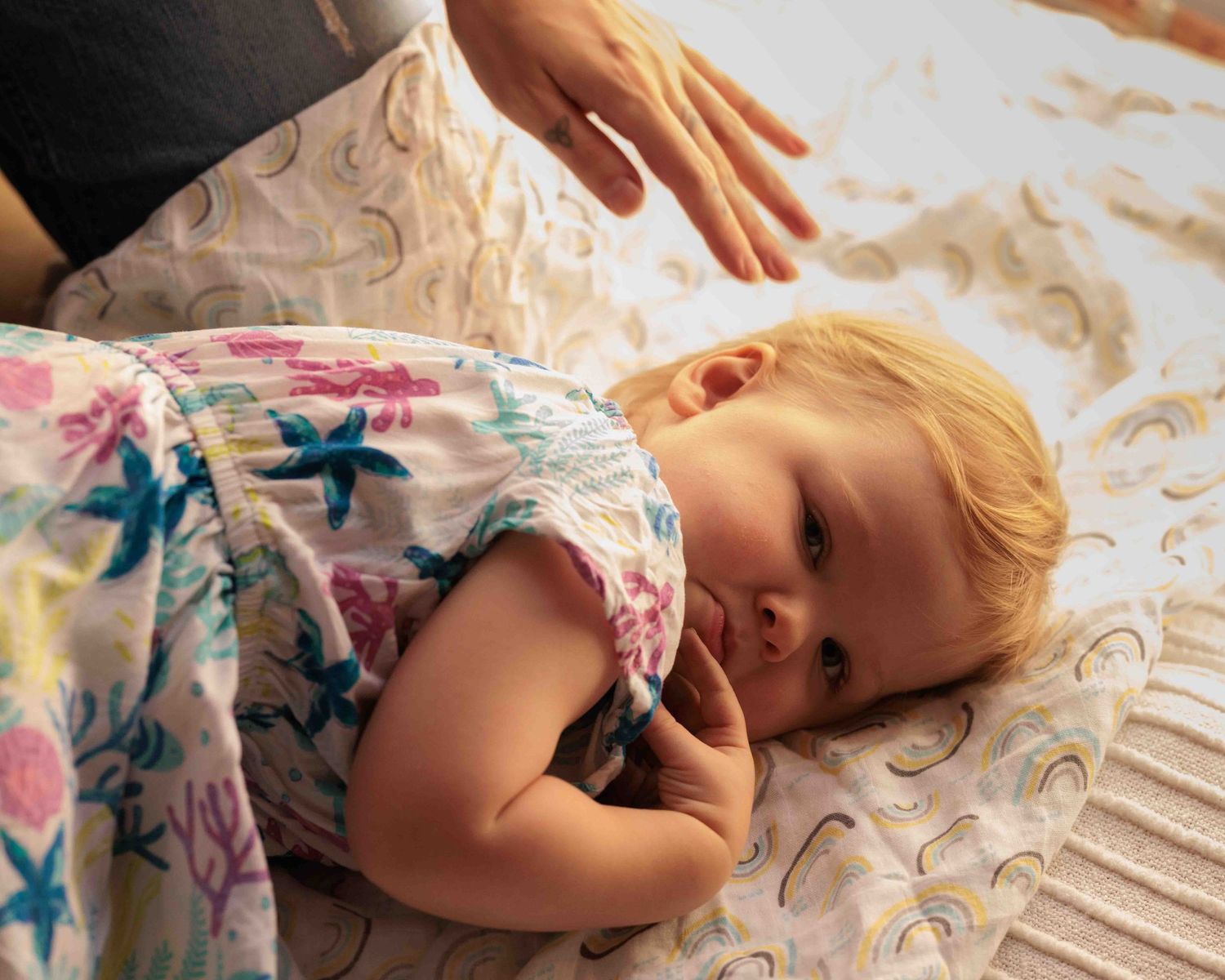 Young child laying on floor looking up at camera. Leigh Ball documentary family photographer