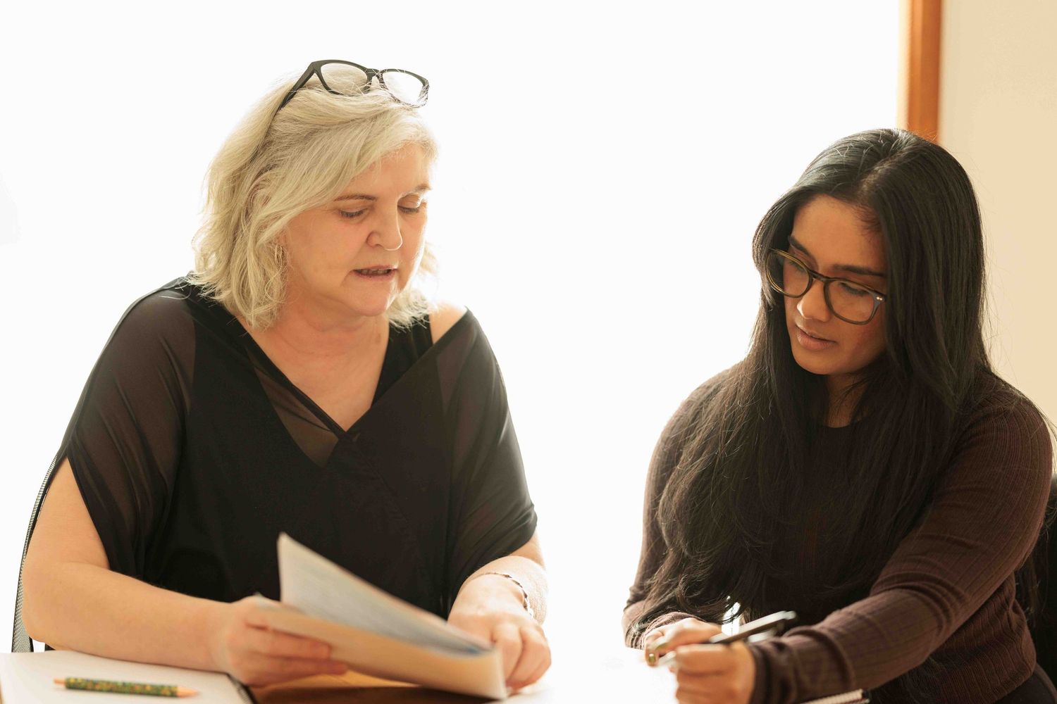 Mentor and client in a discussion looking at a document.