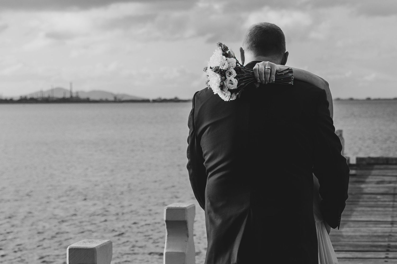 Bride and groom showing bride's wedding ring and flowers. Leigh Ball Documentary wedding photographer