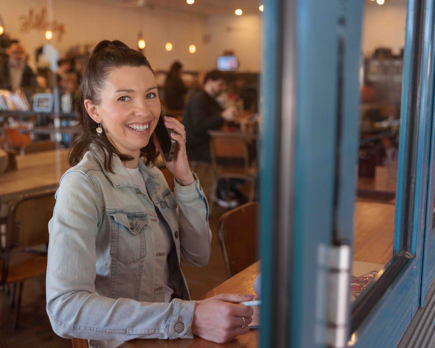 young professional woman on the phone at a cafe