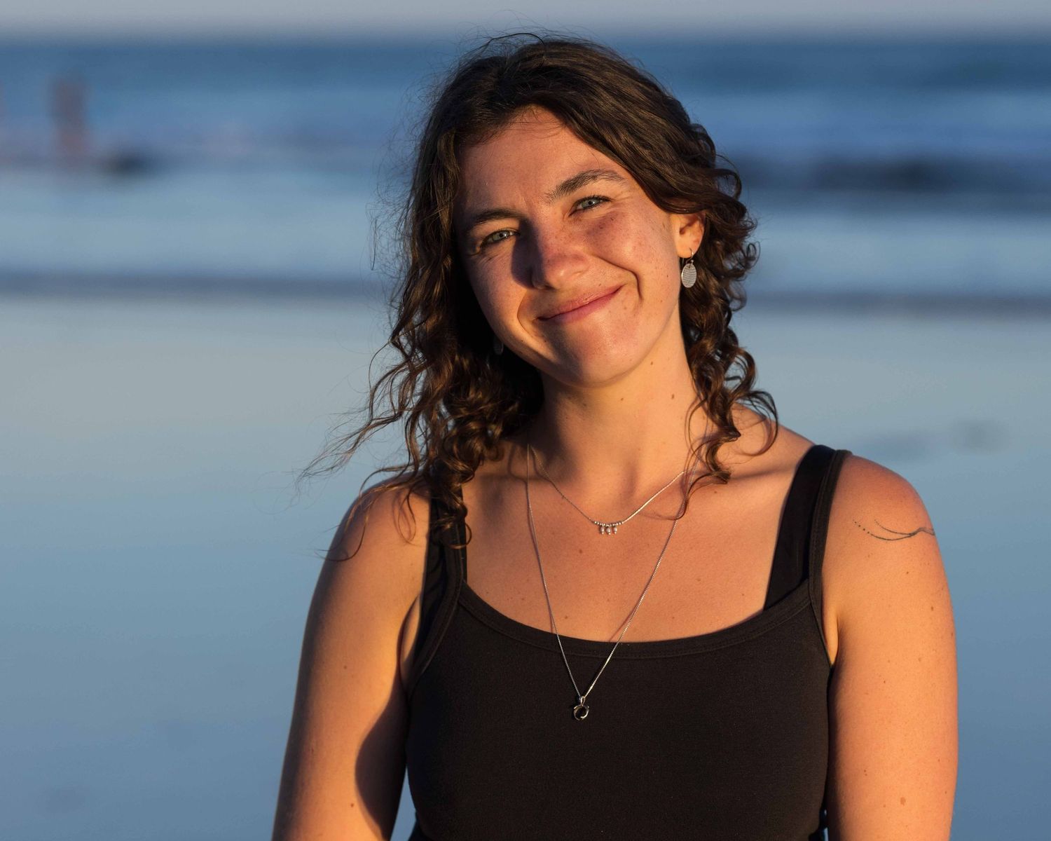 Young woman smiling at camera at the beach.  Leigh Ball Documentary Family Photographer