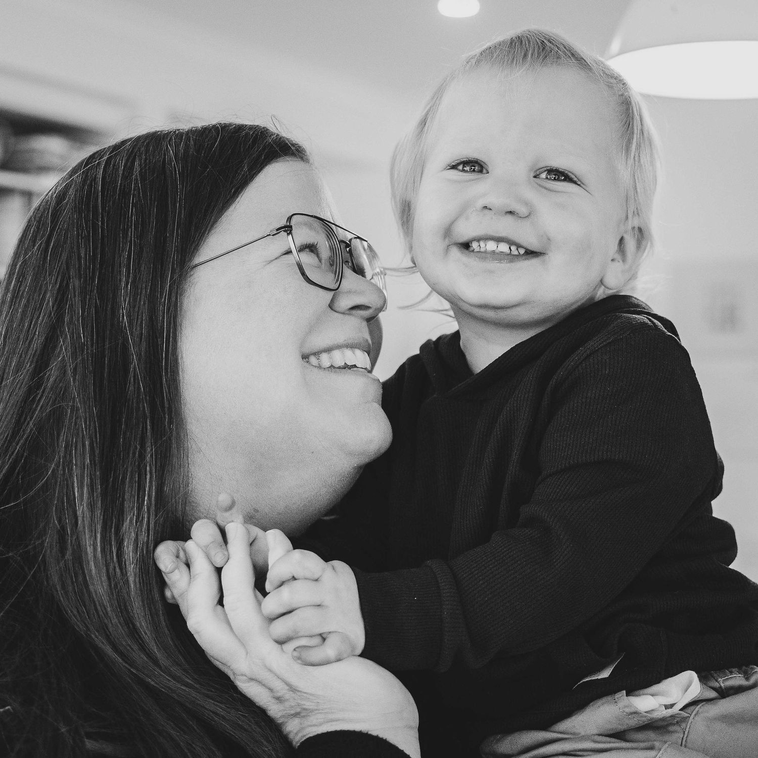 Black and white photo of Mum and young son sharing a laugh.
