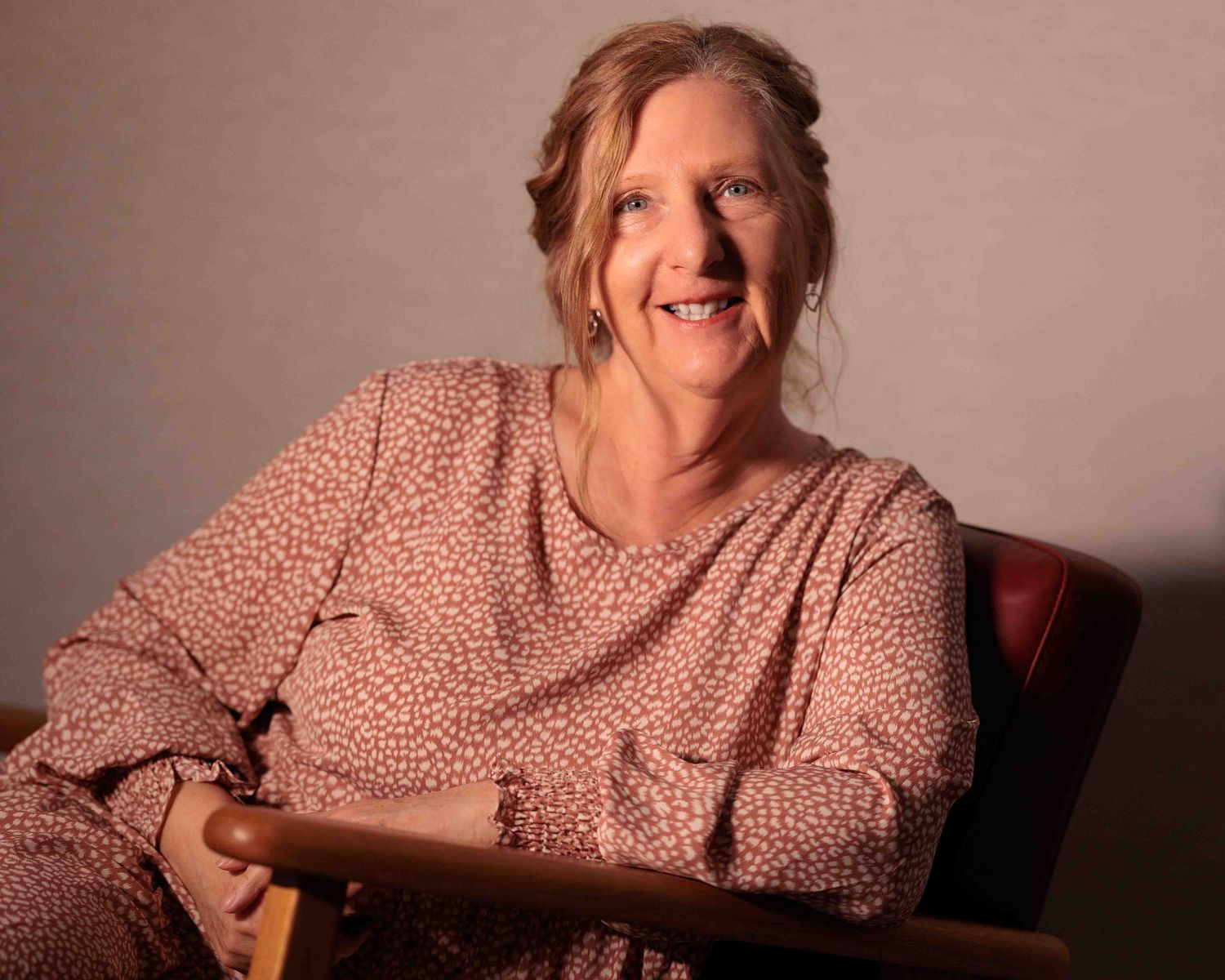 Leigh Ball sitting in a relaxed chair smiling