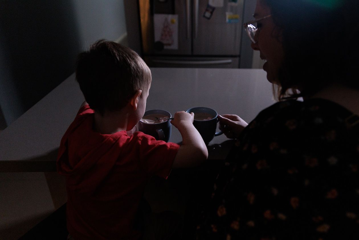 Young child and woman sharing a drink at kitchen bench at Lifestyle Family Photography session