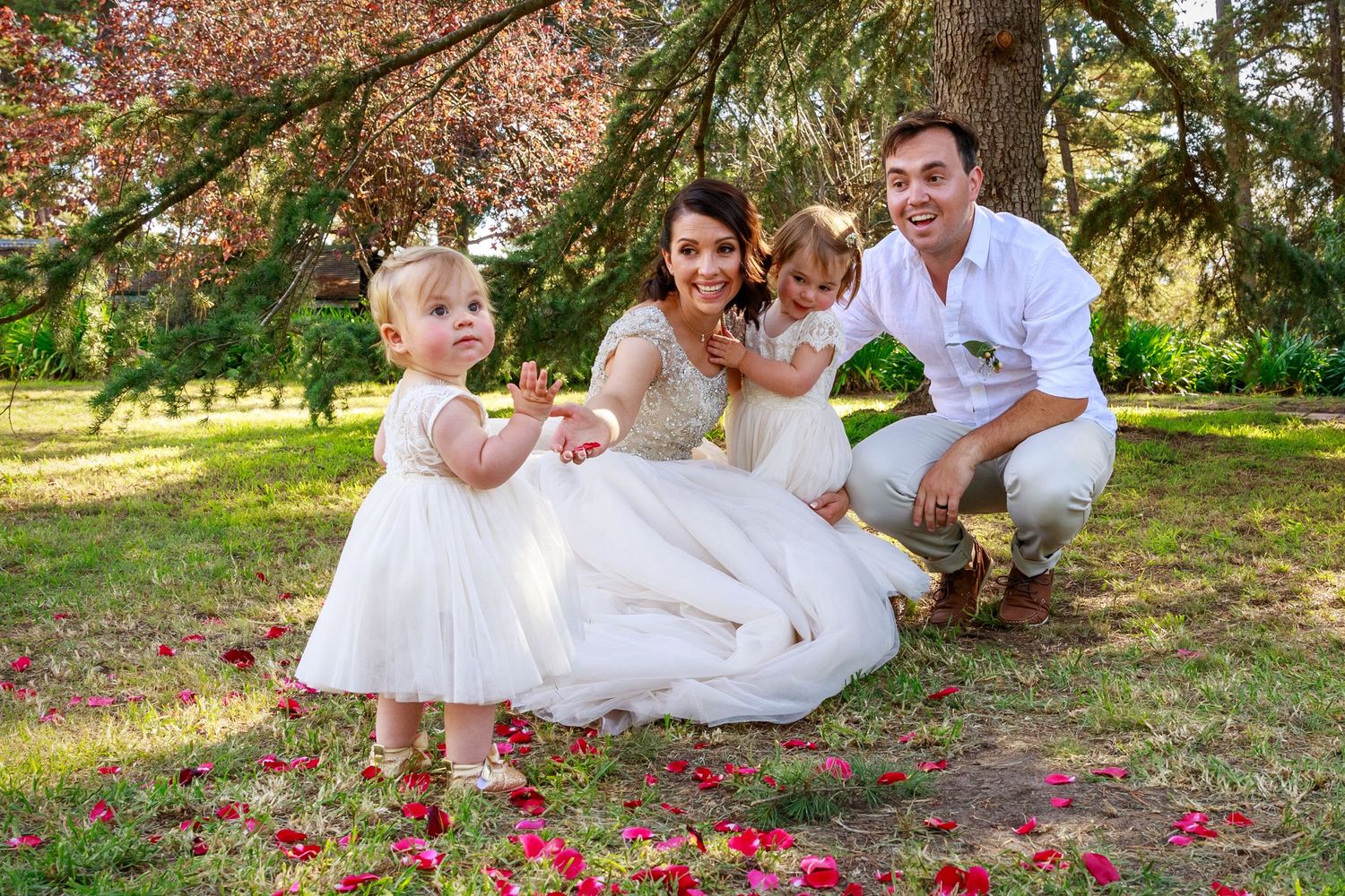 Bride, groom and their two young children at Dromkeen, Riddell's creek wedding, surrounded by rose petals