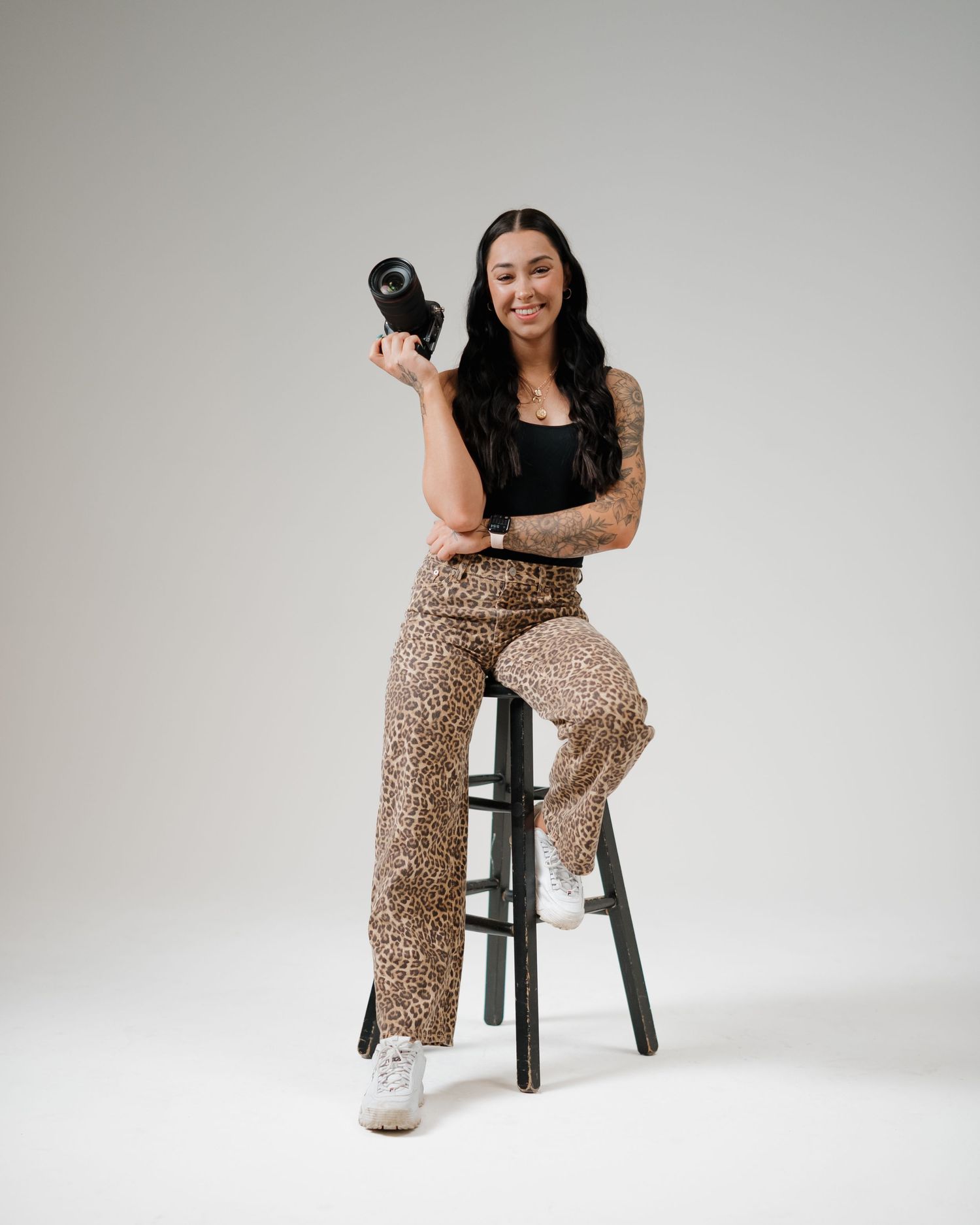 Ontario wedding and fitness photographer holding camera in editorial studio portrait