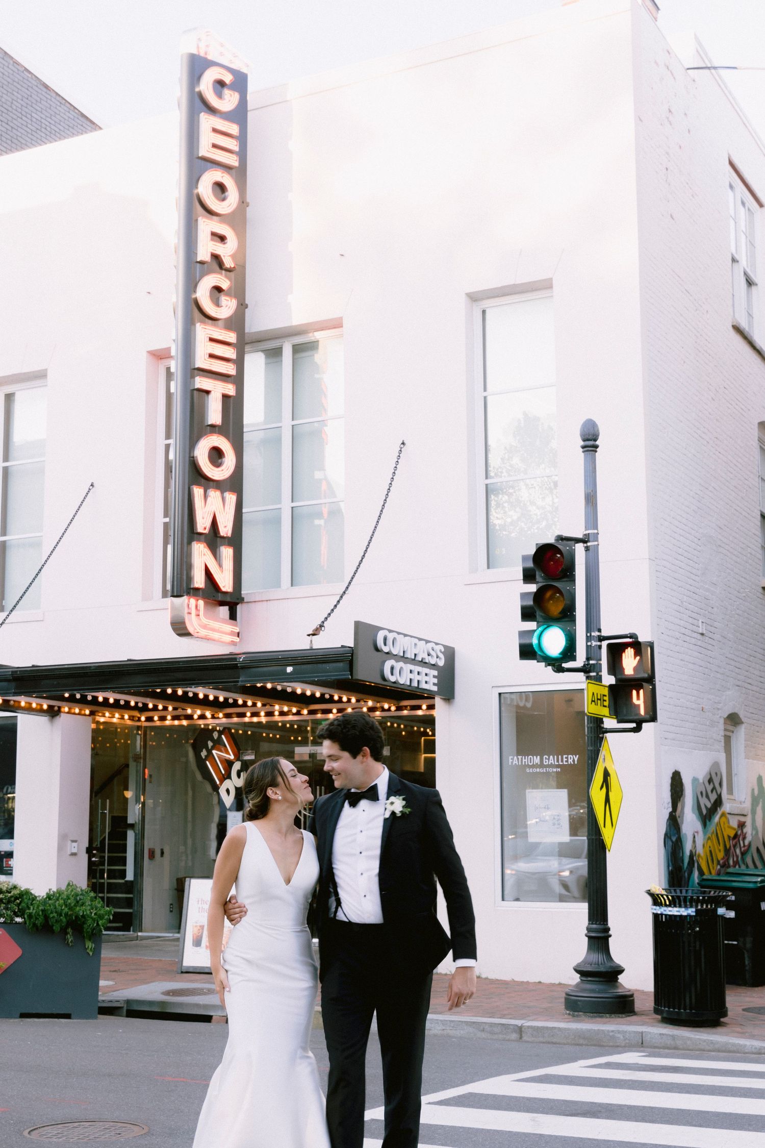 Bride and groom walking past the iconic Georgetown sign in Washington DC on their wedding day.
