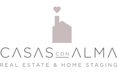 Modern real estate logo design featuring a minimalist house icon and text reading 'CASAS CON ALMA' in elegant typography.