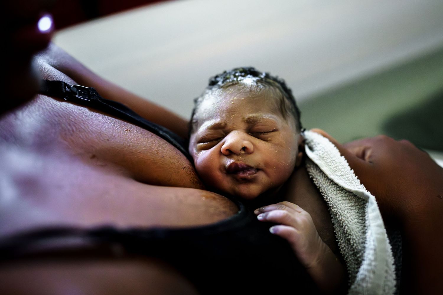 Progressive shots of a newborn being cleaned and examined after delivery.
