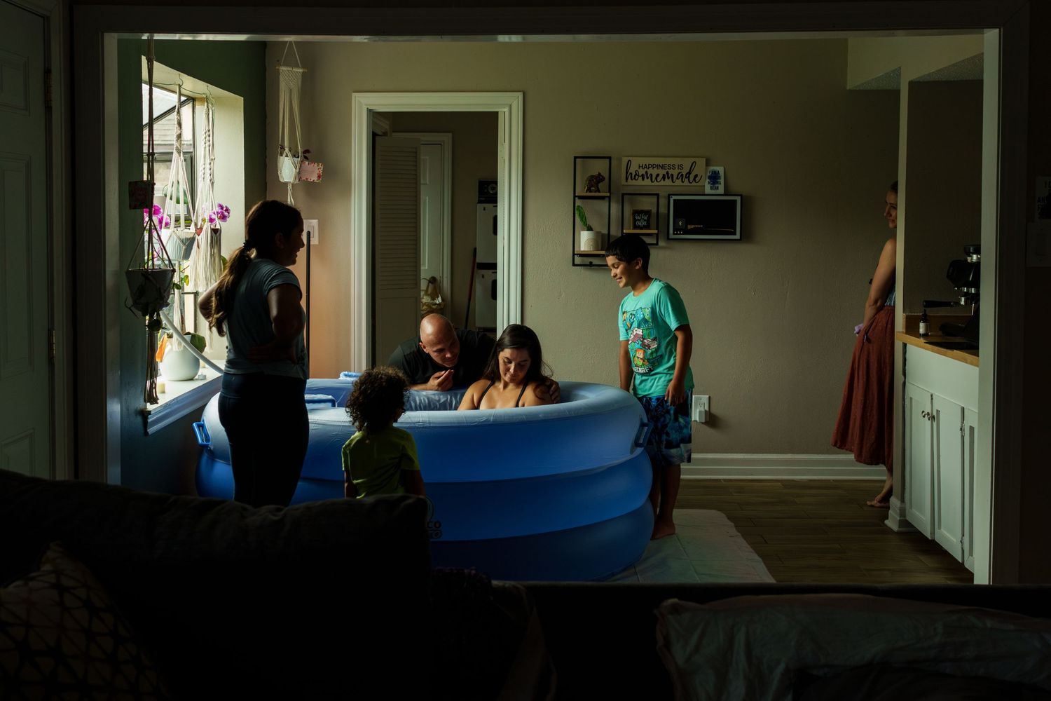 Hospital workers transport a patient on a gurney through dimly lit hallways while wearing protective gear.
