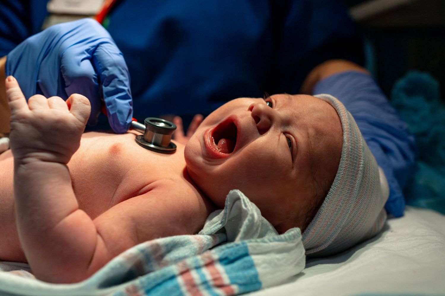 Hospital birth sequence showing first cries of a newborn in blue tones.