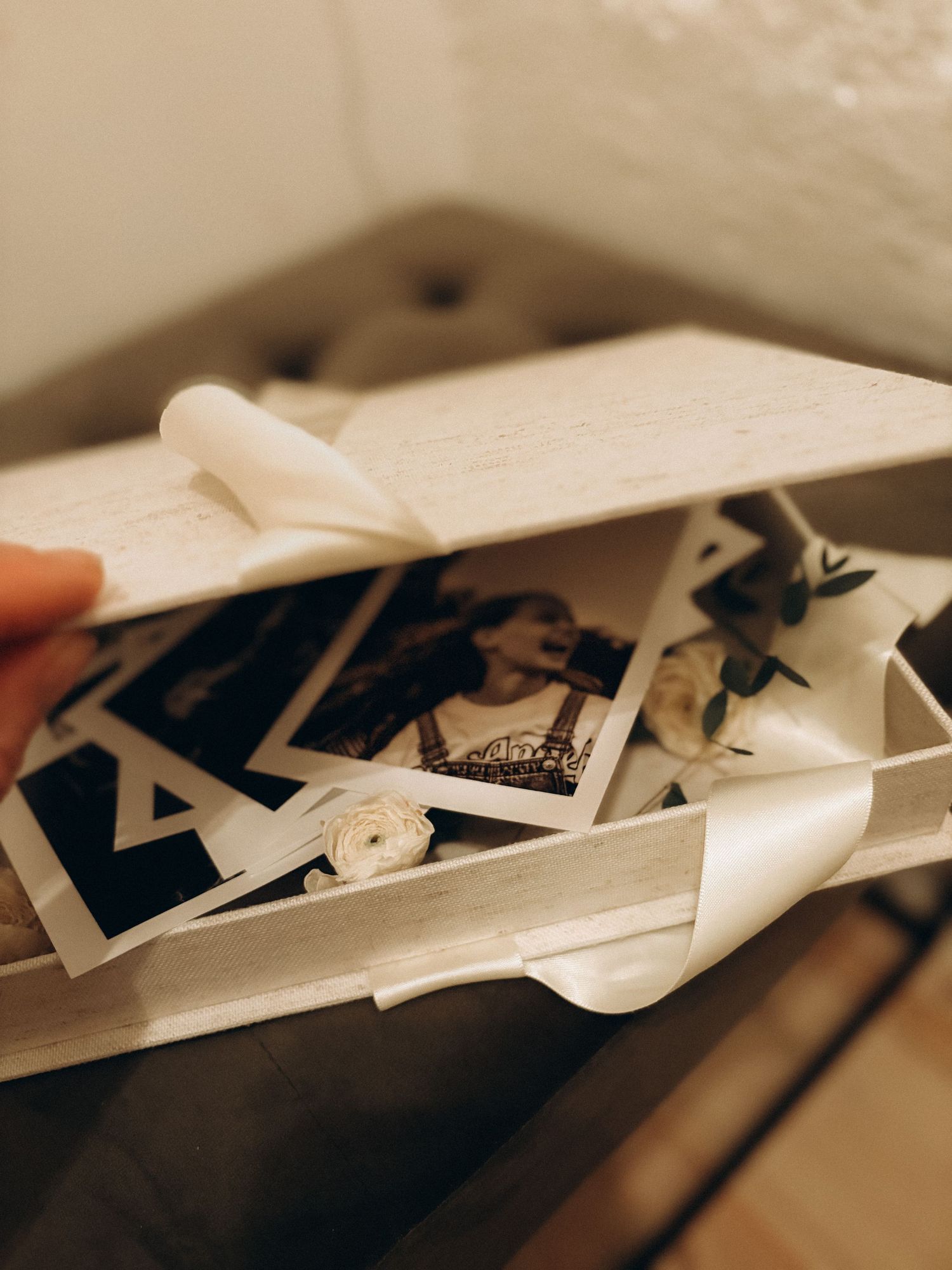 detail of hand opening a box with photos during exhibition for family photographer in Stockholm