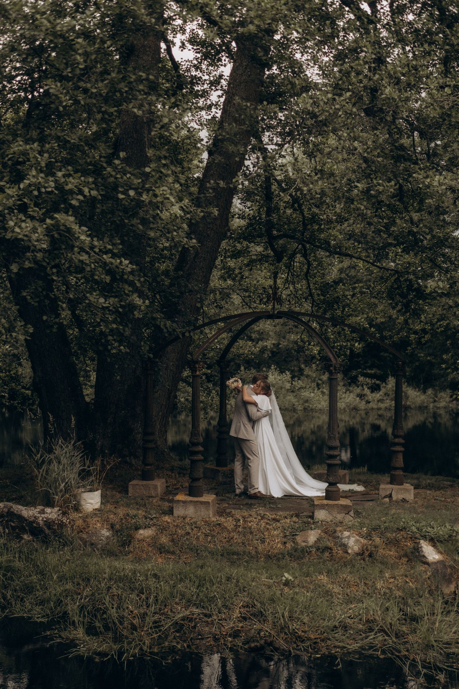 bride and groom hugging in a garden while being captured by wedding photographer in Stockholm with natural style