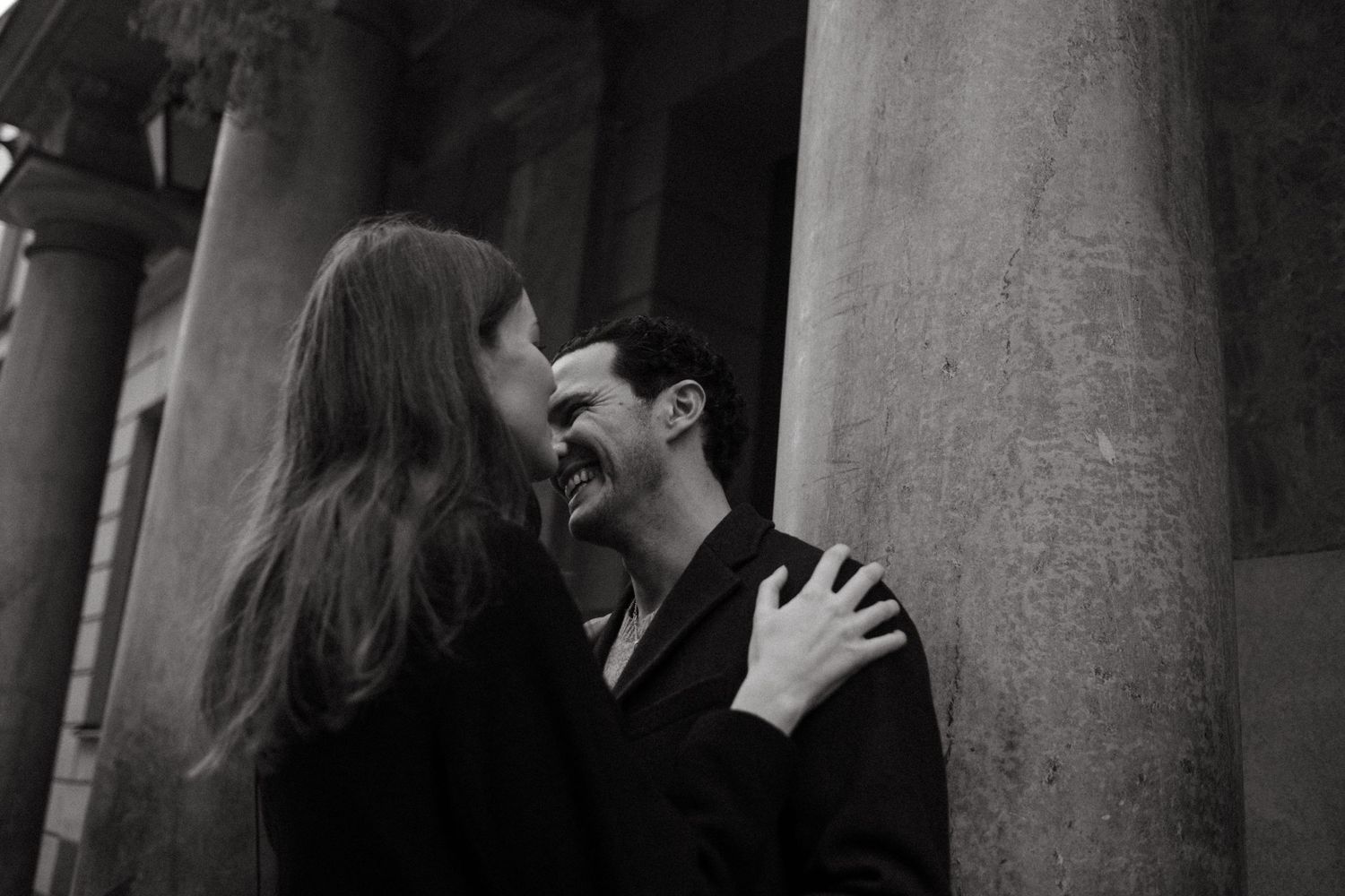 couple sharing a moment of laughter in Gamla Stan during relaxed candid proposal photoshoot in Stockholm without posing