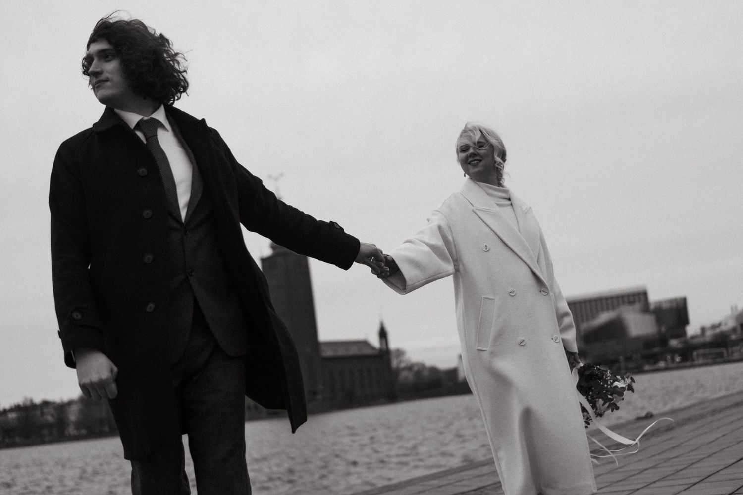 man holding his wife hands and leading her while being captured by elopement photographer in Sweden