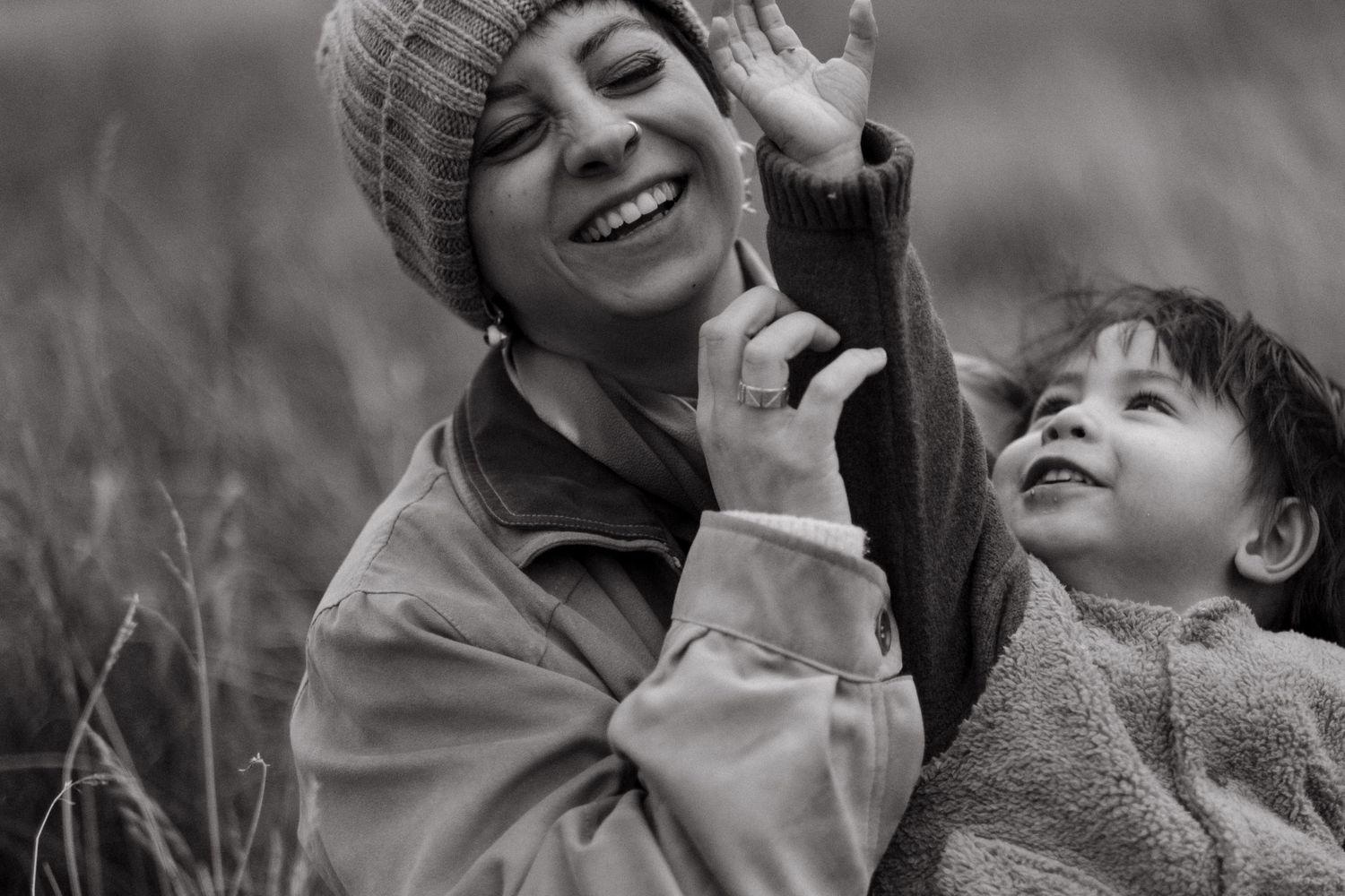 little boy trying to take his mom's hat off her head while being captured by English-speaking family photographer for expats in Stockholm