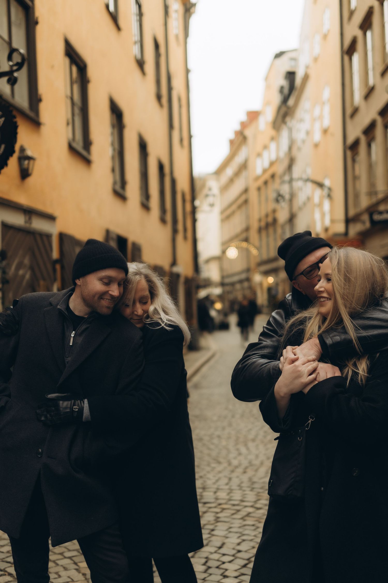 family sharing a moment where mom hugs son and dad hugs daughter during family vacation photoshoot in Stockholm during Christmas