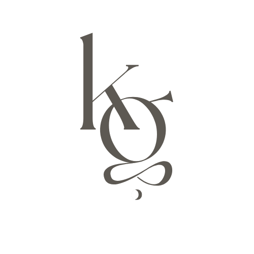 Stylized monogram design combining letters k and g with decorative serif details and flourishes in a dark grey color.
