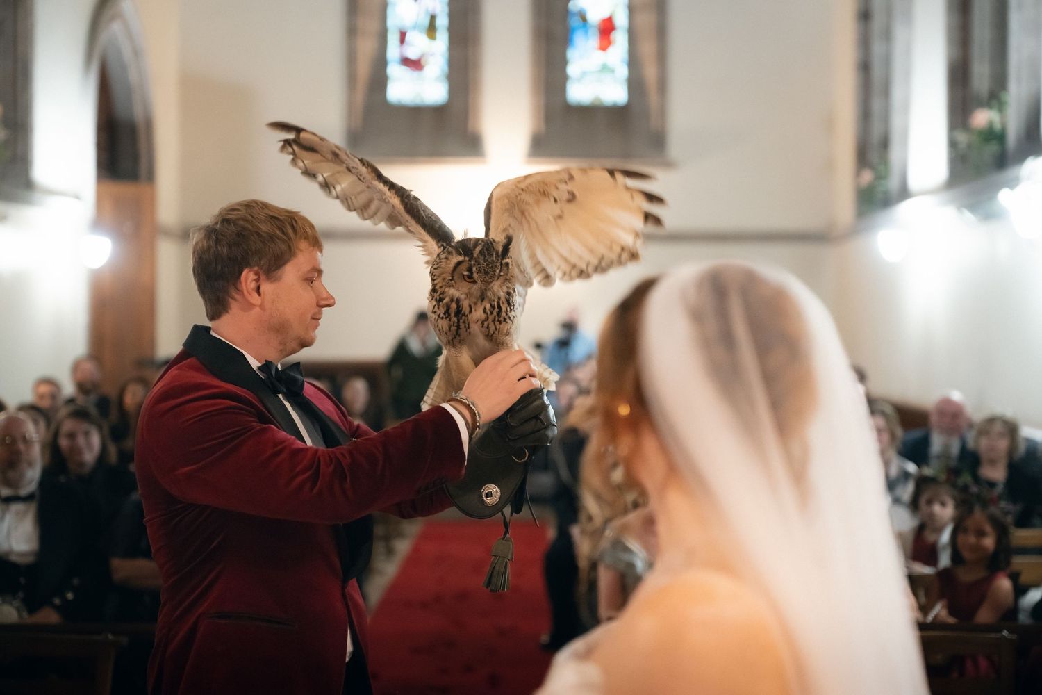 A bride and groom dance together during their first dance at a wedding reception while guests look on.