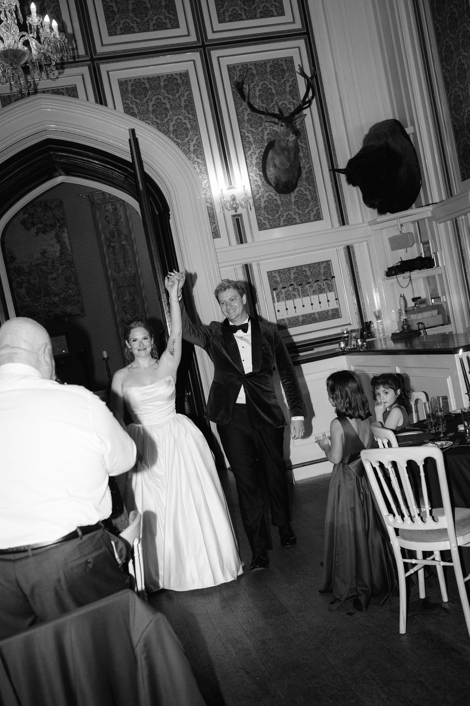 Black and white photo of guests dancing at an elegant indoor reception.