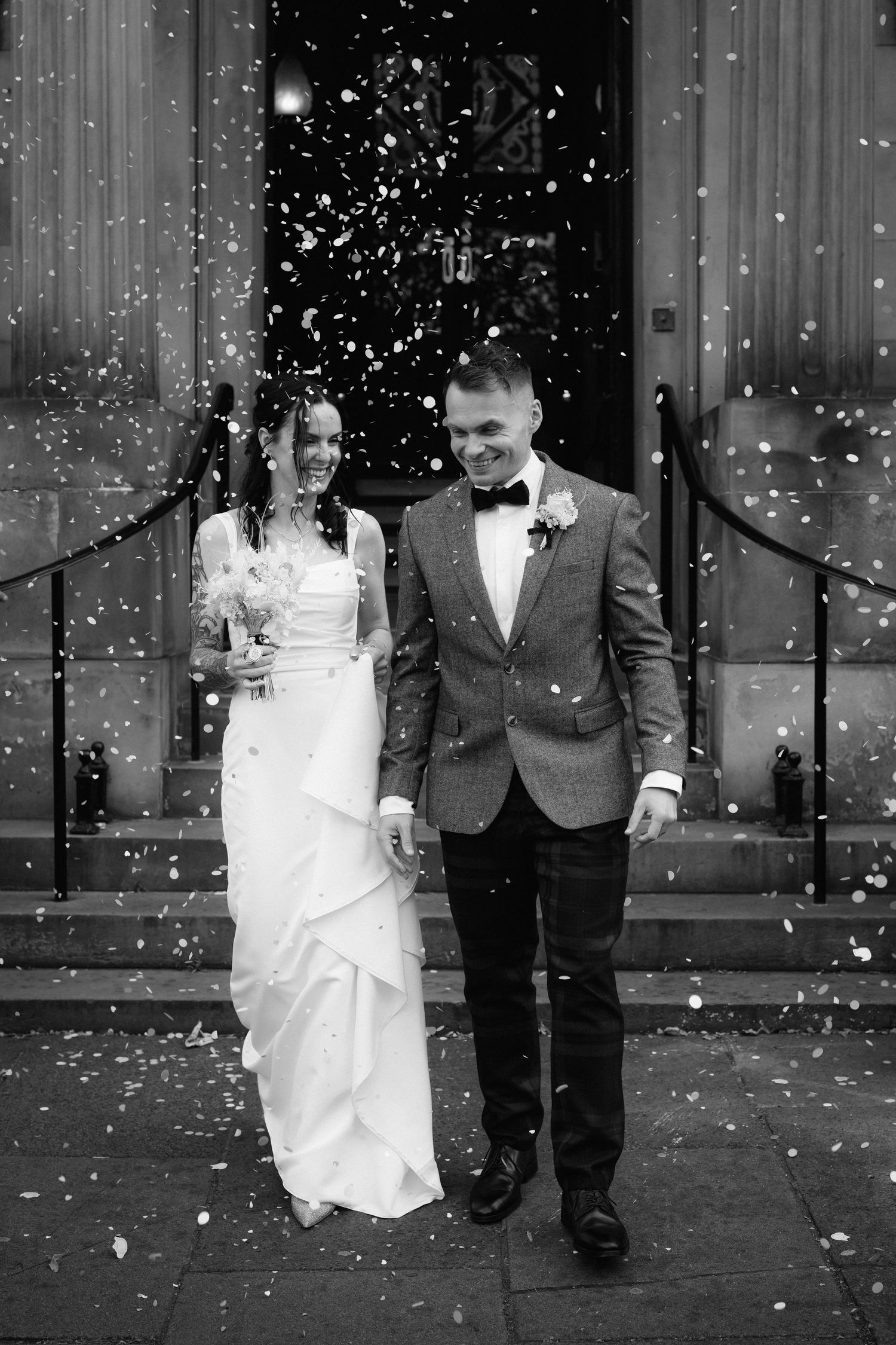 A black and white wedding photo sequence showing a couple walking together while snow falls around them.