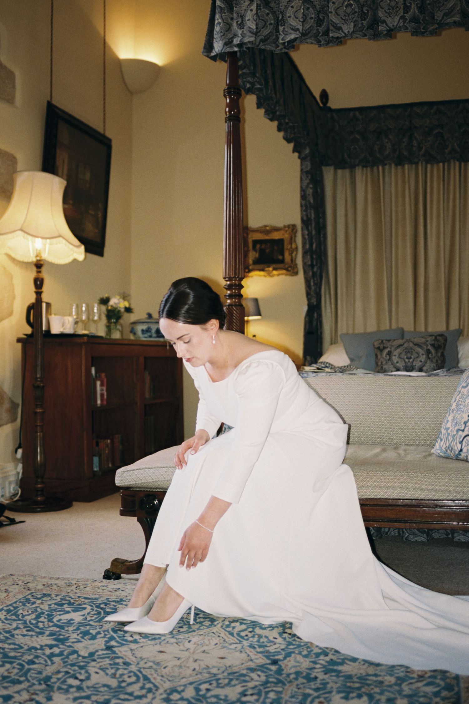 A series of four photos showing a person in a white dress reclining on a luxurious blue and white bedspread.