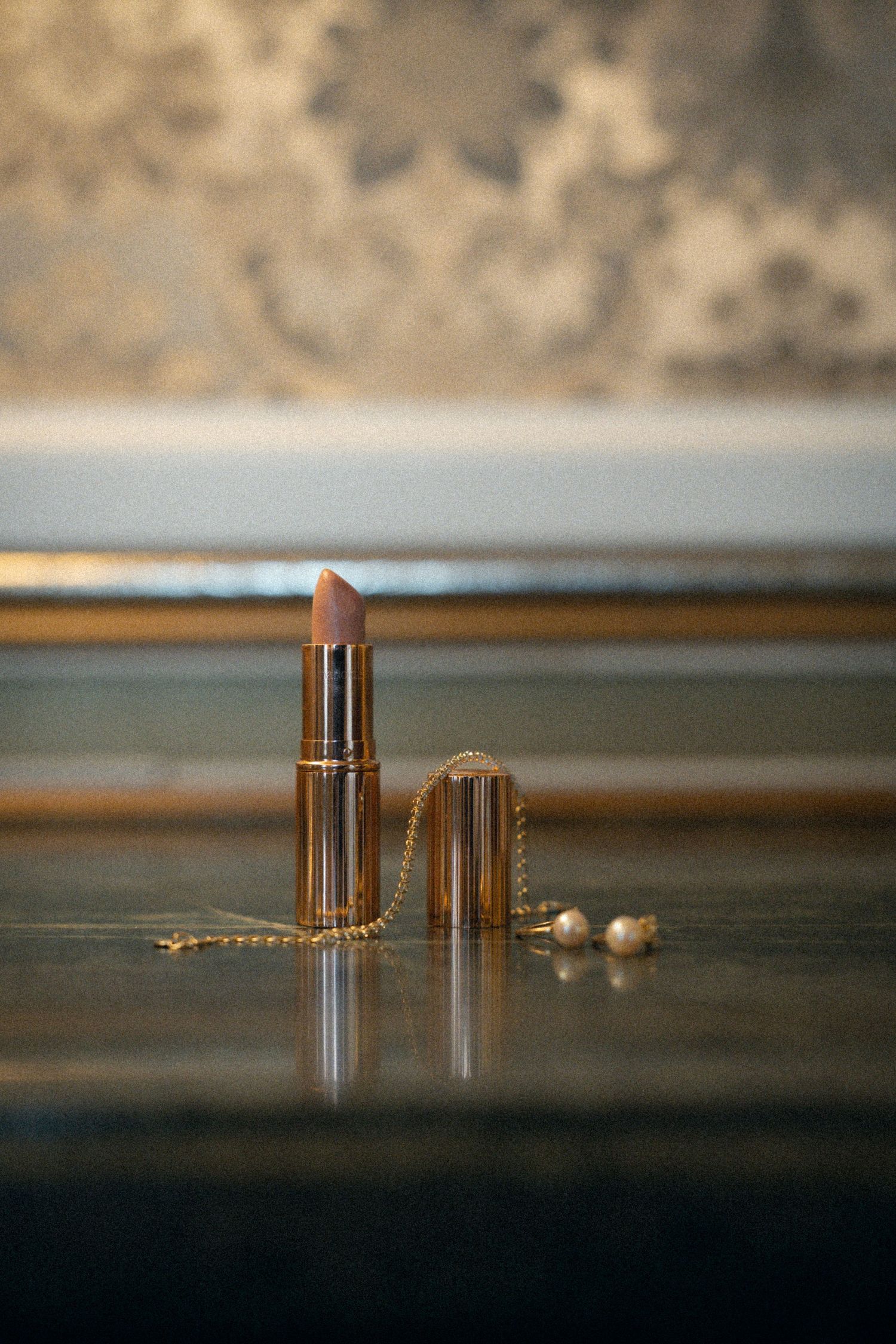 Four bullet cartridges arranged in a row on a reflective dark surface with shallow depth of field.