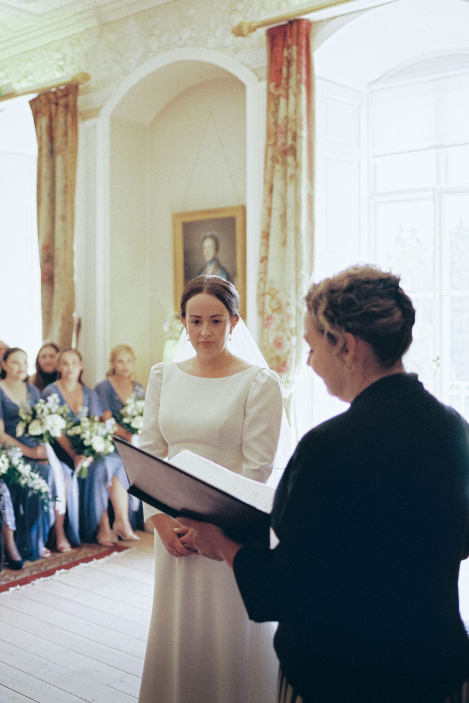 Three candid moments captured during a wedding ceremony preparation in an elegant room with white walls and red curtains.
