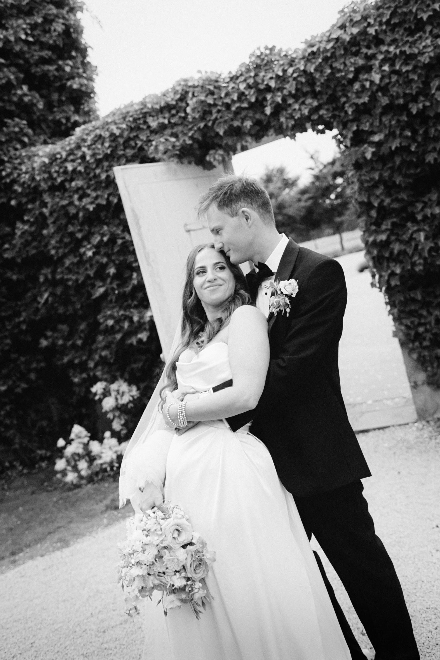 A romantic black and white wedding photo sequence showing the couple embracing in an outdoor garden setting.
