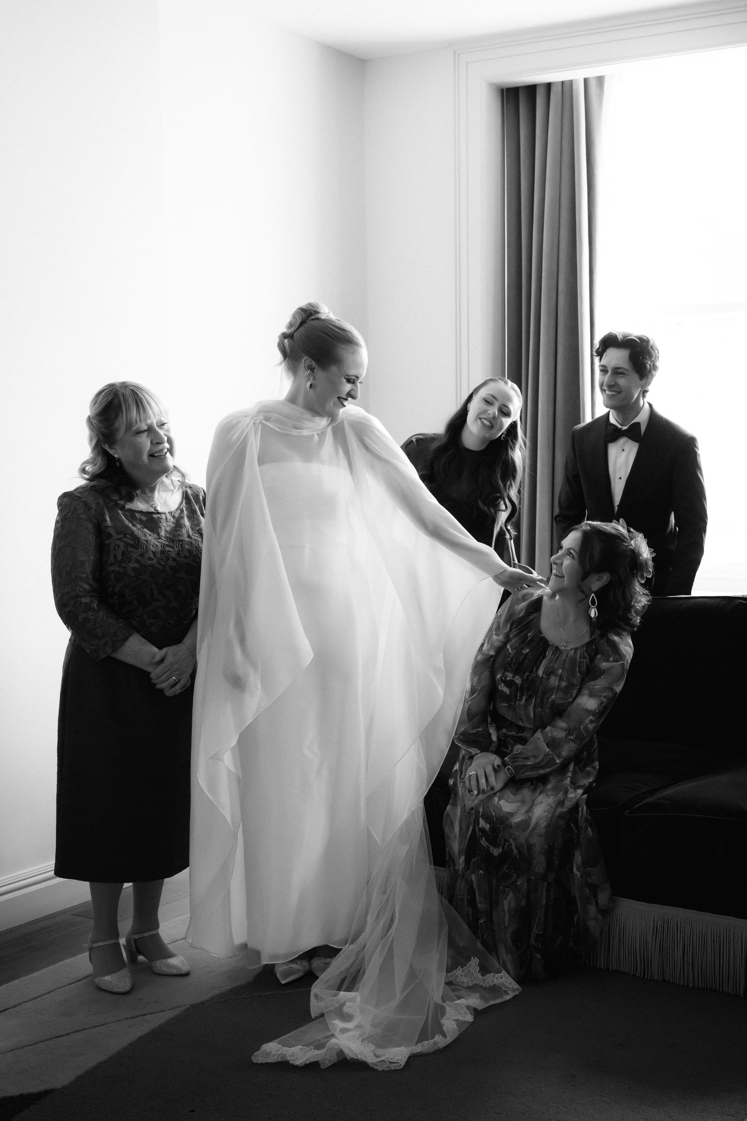 Black and white photo series showing preparations for a wedding with a flowing white dress and emotional moments.