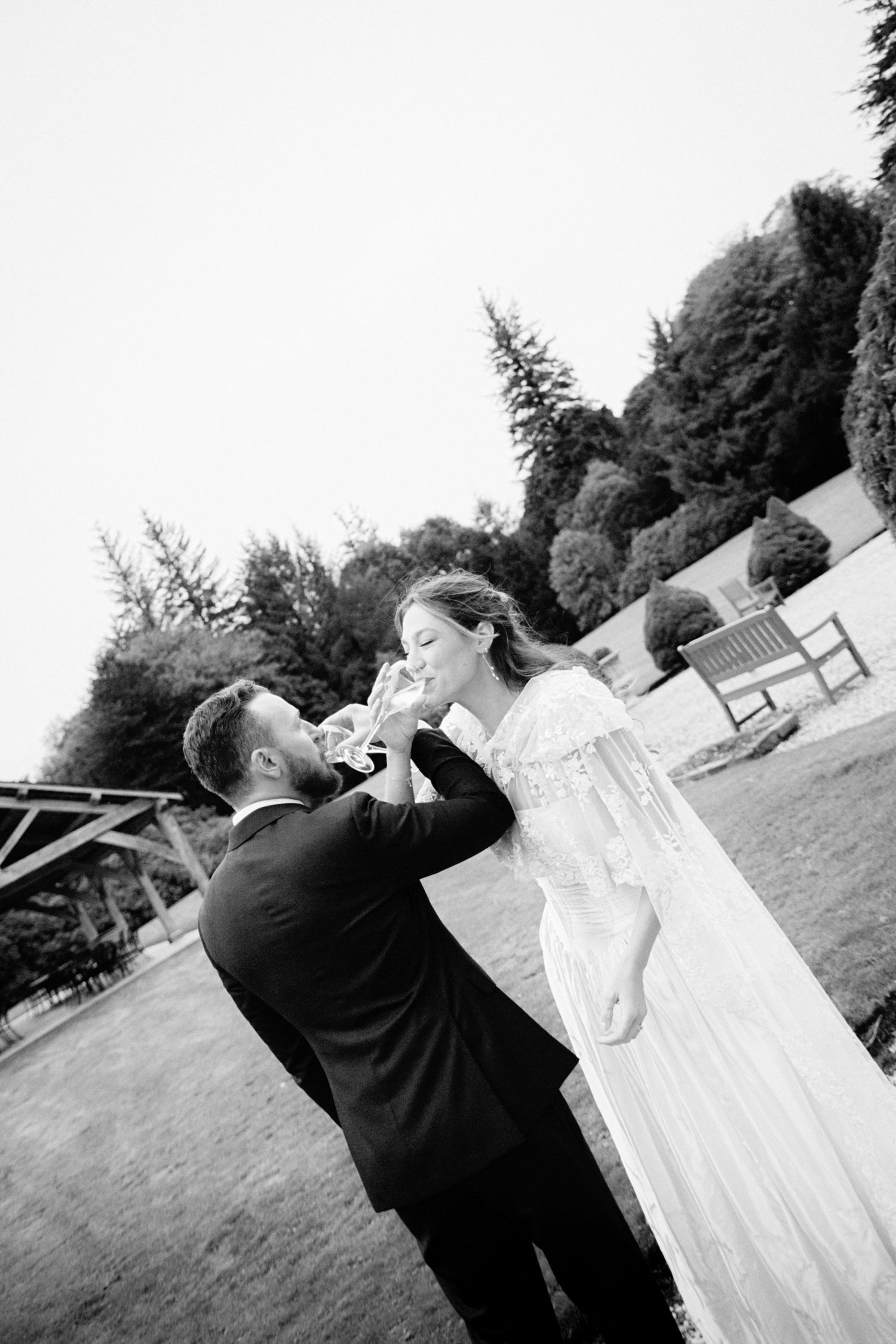 A series of black and white wedding photos showing a couple dancing in an outdoor garden setting.
