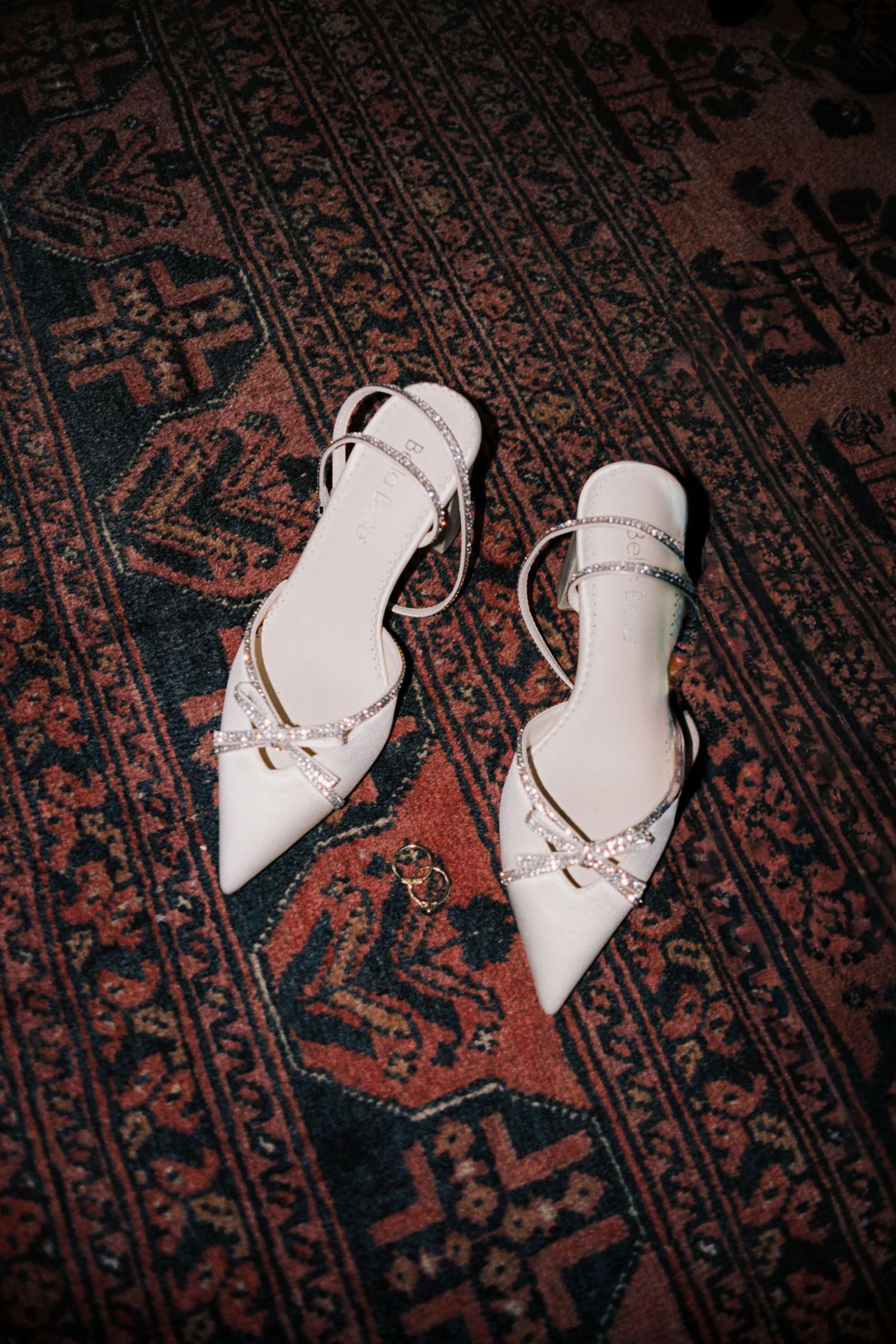 White leather ballet flats with laces rest on a vintage patterned rug in a sequence of eight similar shots.