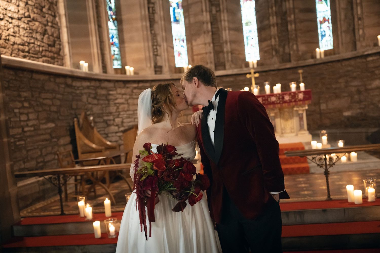 A romantic church wedding ceremony with candles lining the aisle and exposed brick walls creating an intimate atmosphere.