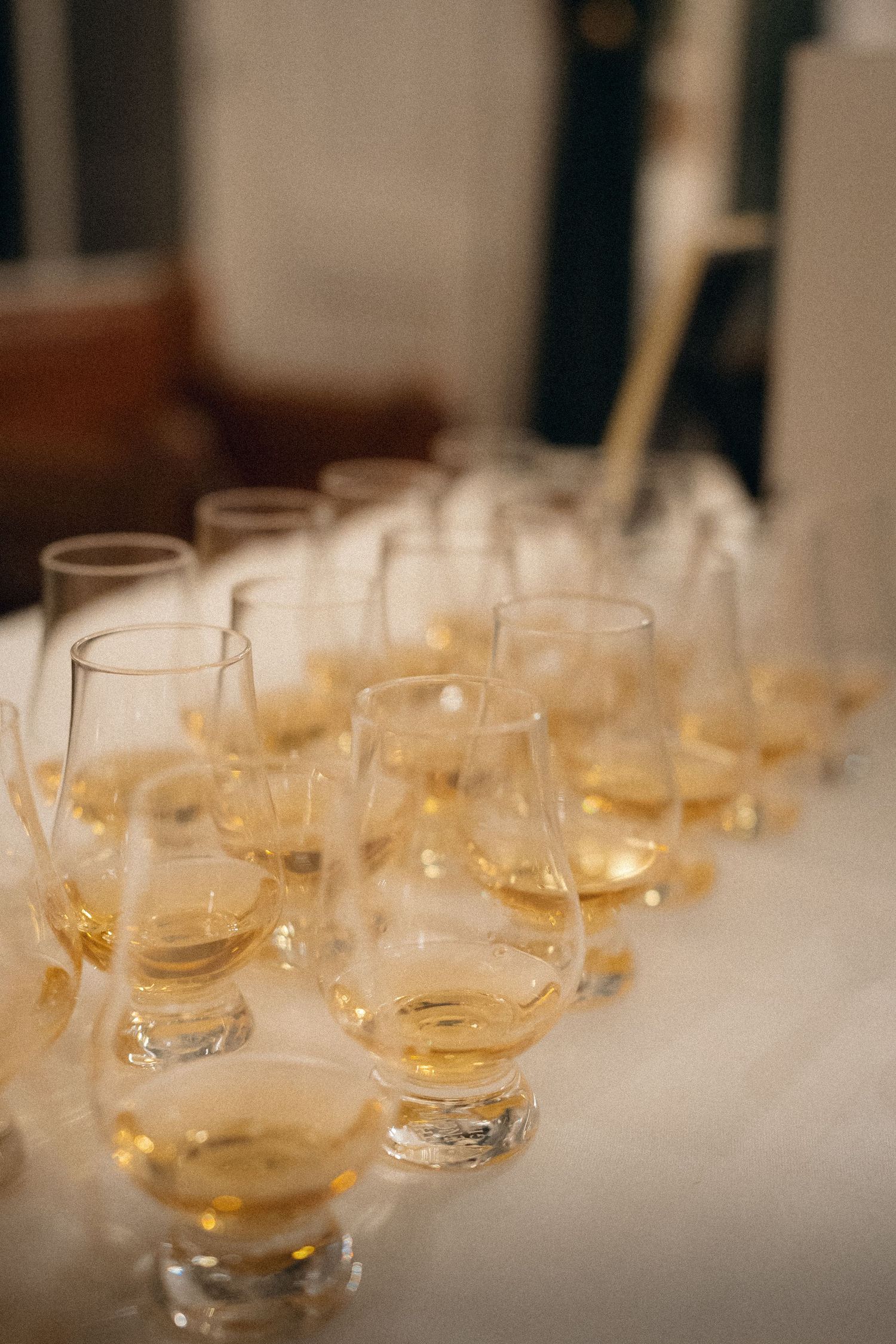 Rows of empty wine glasses arranged on a table at an elegant event.