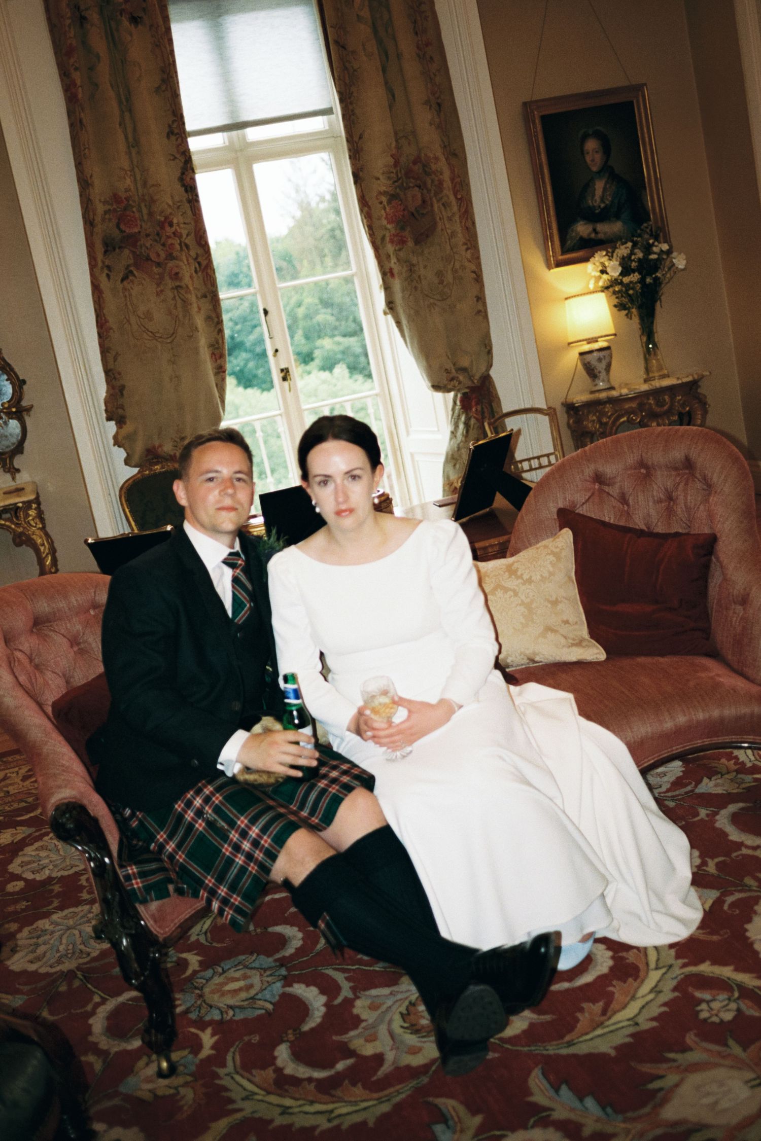 A series of wedding photos showing a couple seated on vintage pink chairs in an elegant room with floral curtains.
