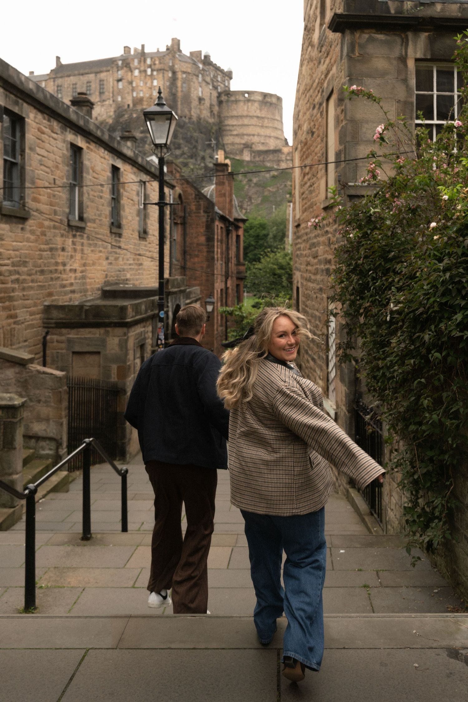 A sequence of photos showing tourists walking along a historic cobblestone street with Edinburgh Castle visible in the distance.