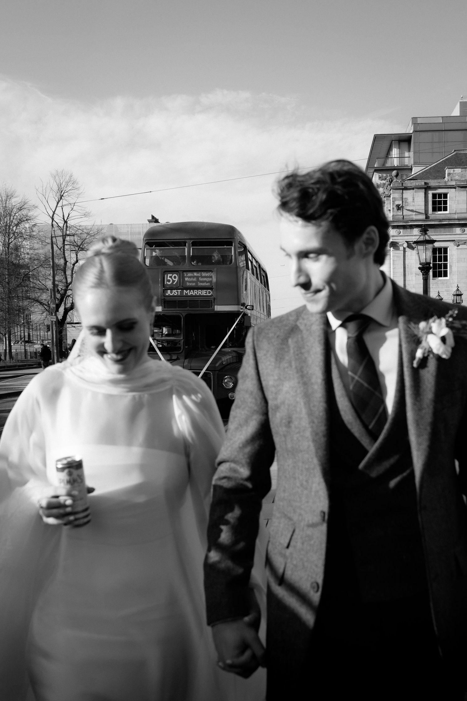 A vintage black and white wedding photo showing a couple walking together with a train visible in the background.