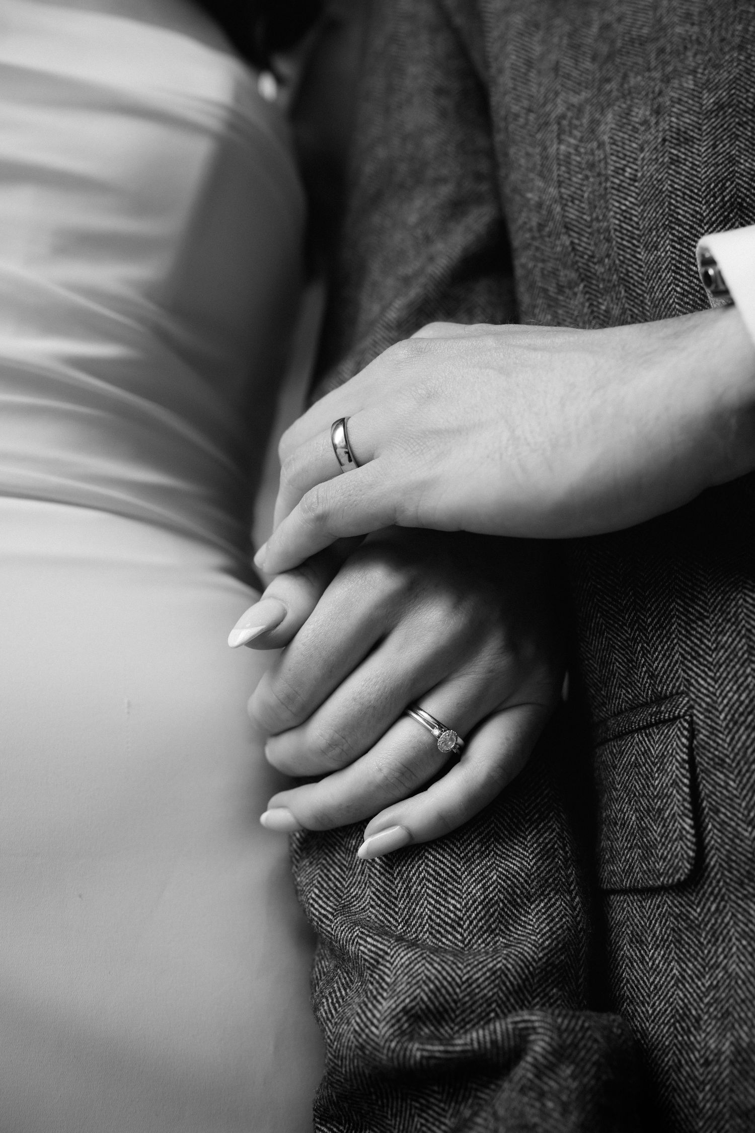 A series of black and white photographs showing hands with wedding rings resting on a dark textured surface.