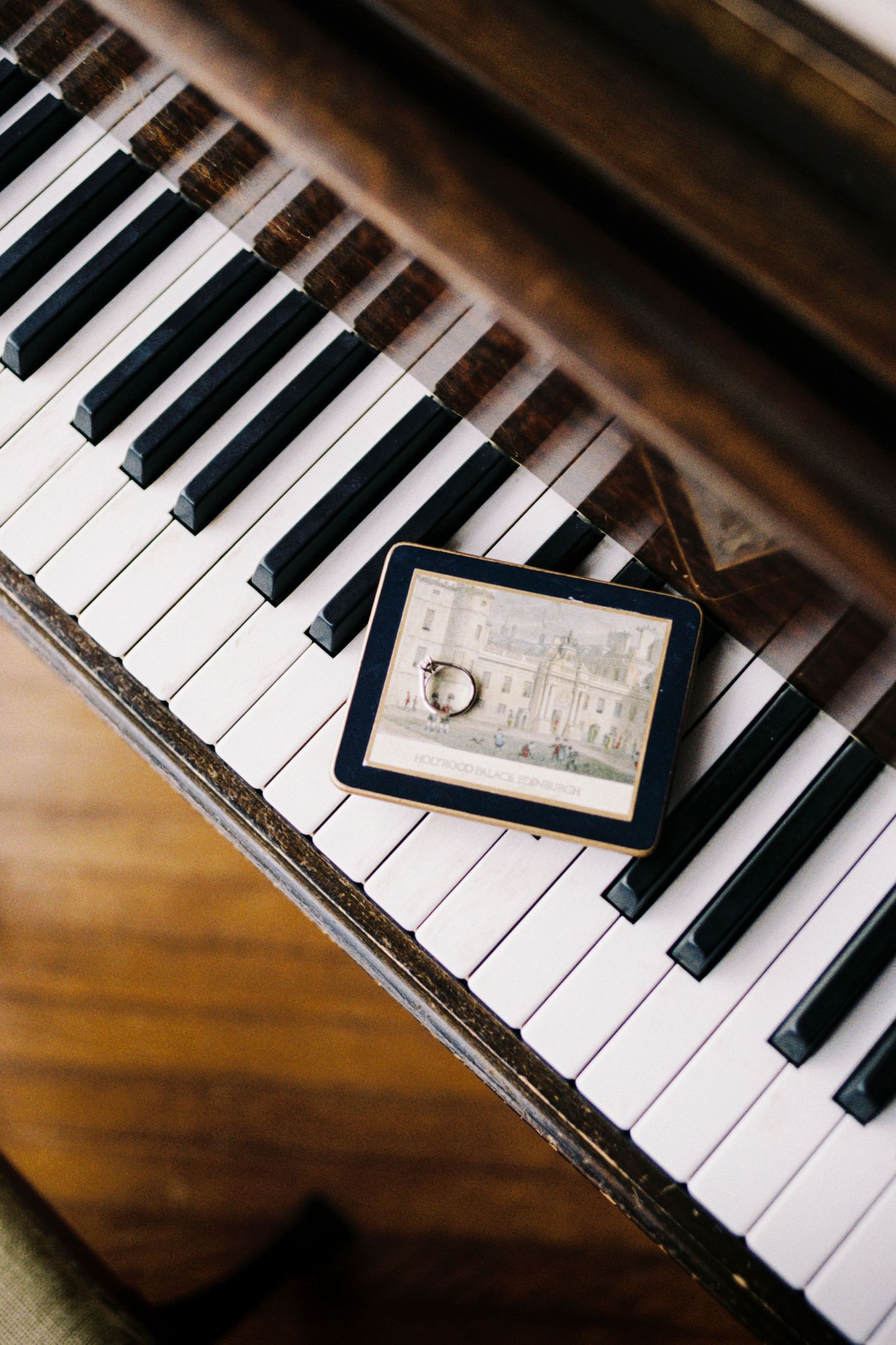 Wedding rings and engagement jewelry displayed artistically on black and white piano keys.