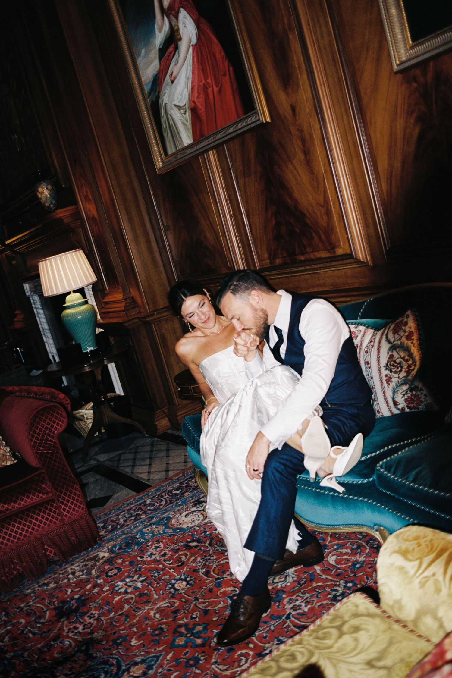 A couple shares a romantic dip dance move in an elegant wood-paneled room with ornate rugs and vintage furniture.