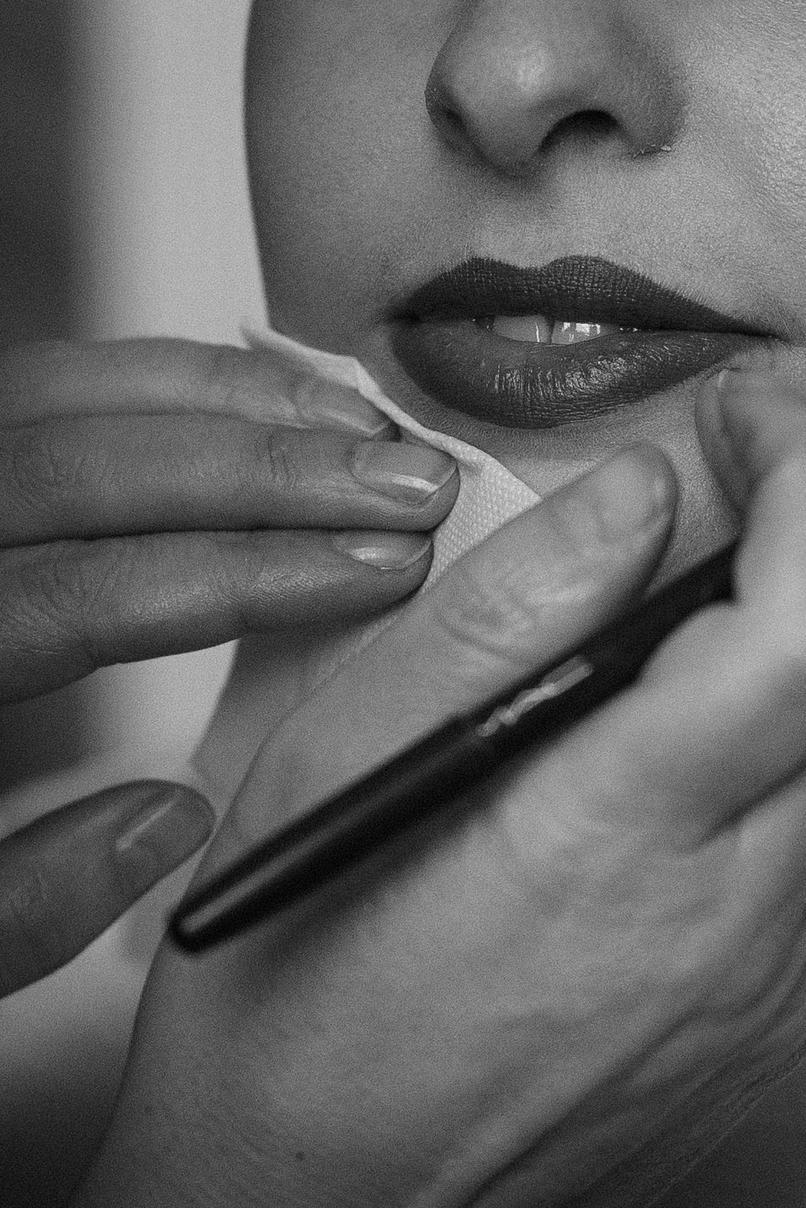 Black and white close-up photo series showing fingers gently touching lips in an artistic sequence.