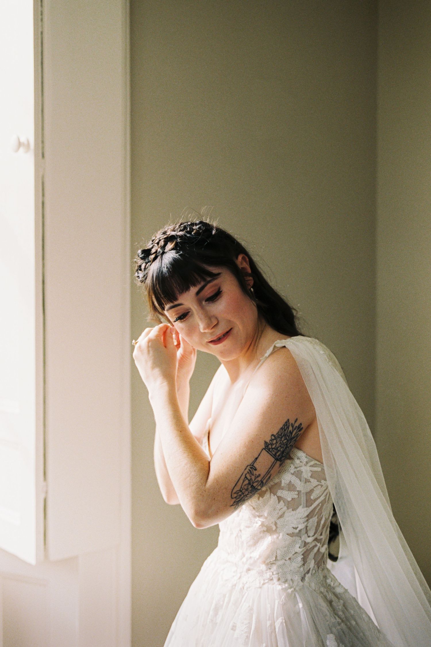 A dreamy bridal portrait series in soft natural light showing a white wedding gown and flowing veil.