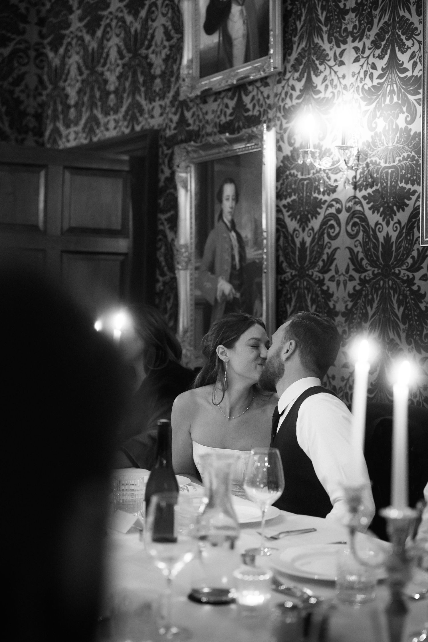 A romantic black and white sequence of candlelit dining scenes with wine glasses and elegant table settings.