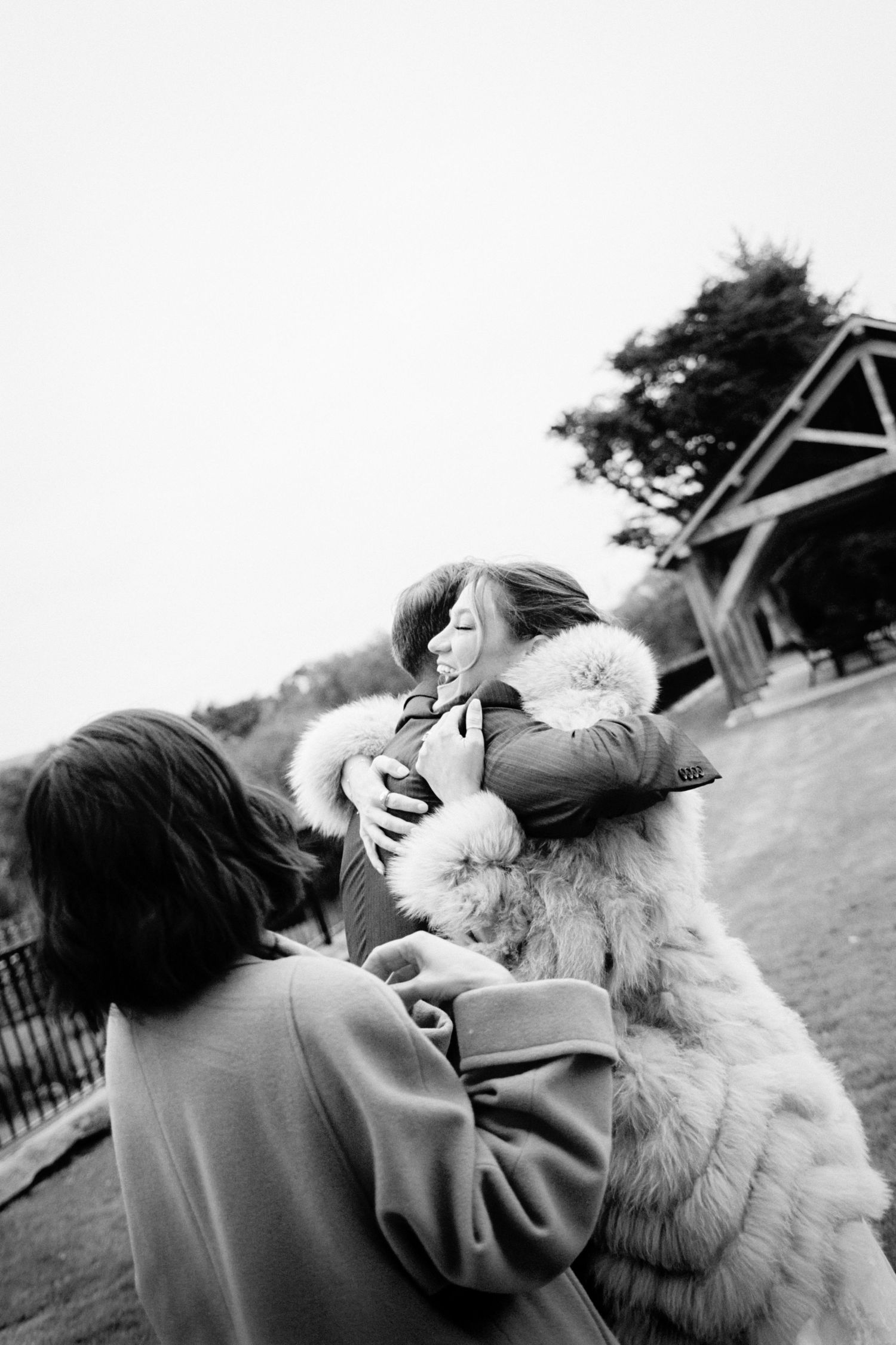 A playful black and white photo sequence showing a person interacting with a fluffy white dog outdoors.